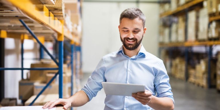 Handsome man warehouse worker with a tablet.