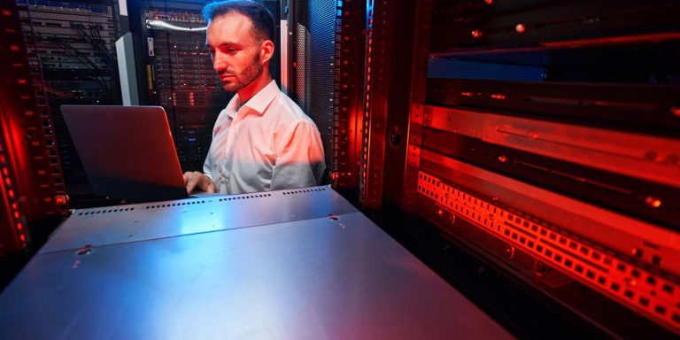 Homem segurando notebook escolhendo software erp